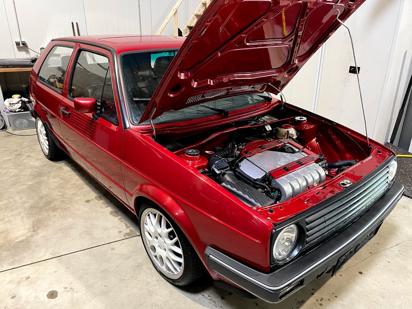 Roter VW Golf 2 mit VR6-Motor und geöffneter Haube in der Werkstatt